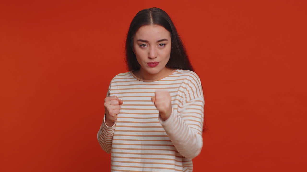 mujer agresiva enojada tratando de pelear en la cámara, sacudiendo el puño, boxeo con expresión, castigo