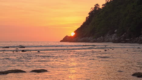 Un-Espectacular-Sol-Naranja-Se-Esconde-Detrás-De-Una-Montaña-A-Lo-Largo-De-La-Costa