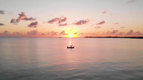 drone volando en el océano al atardecer hacia un barco