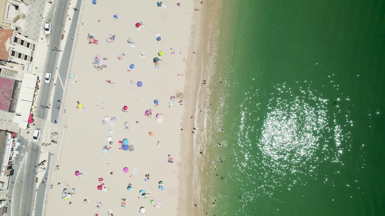포르투갈 세심브라 해변에서 목욕과 일광욕을 즐기는 사람들