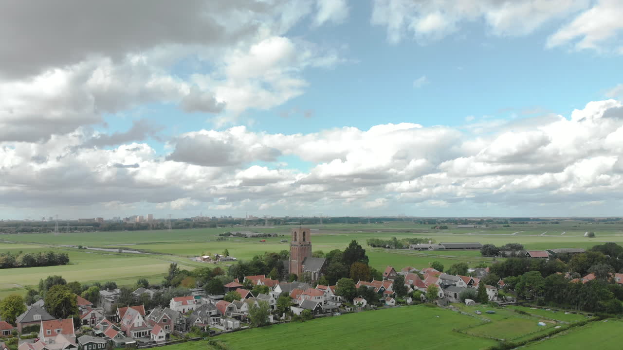 농업 환경이 있는 ransdorp 마을과 구름이 있는 푸른 하늘을 배경으로 네덜란드의 암스테르담 시를 보여주는 공중 기울기