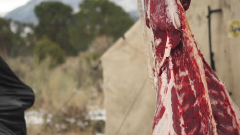 Hombre-Vestido-De-Campo-De-Camuflaje-Extrayendo-Carne-De-Venado-En-El-Campamento-De-Caza