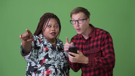 overweight african woman and young scandinavian man together against green background