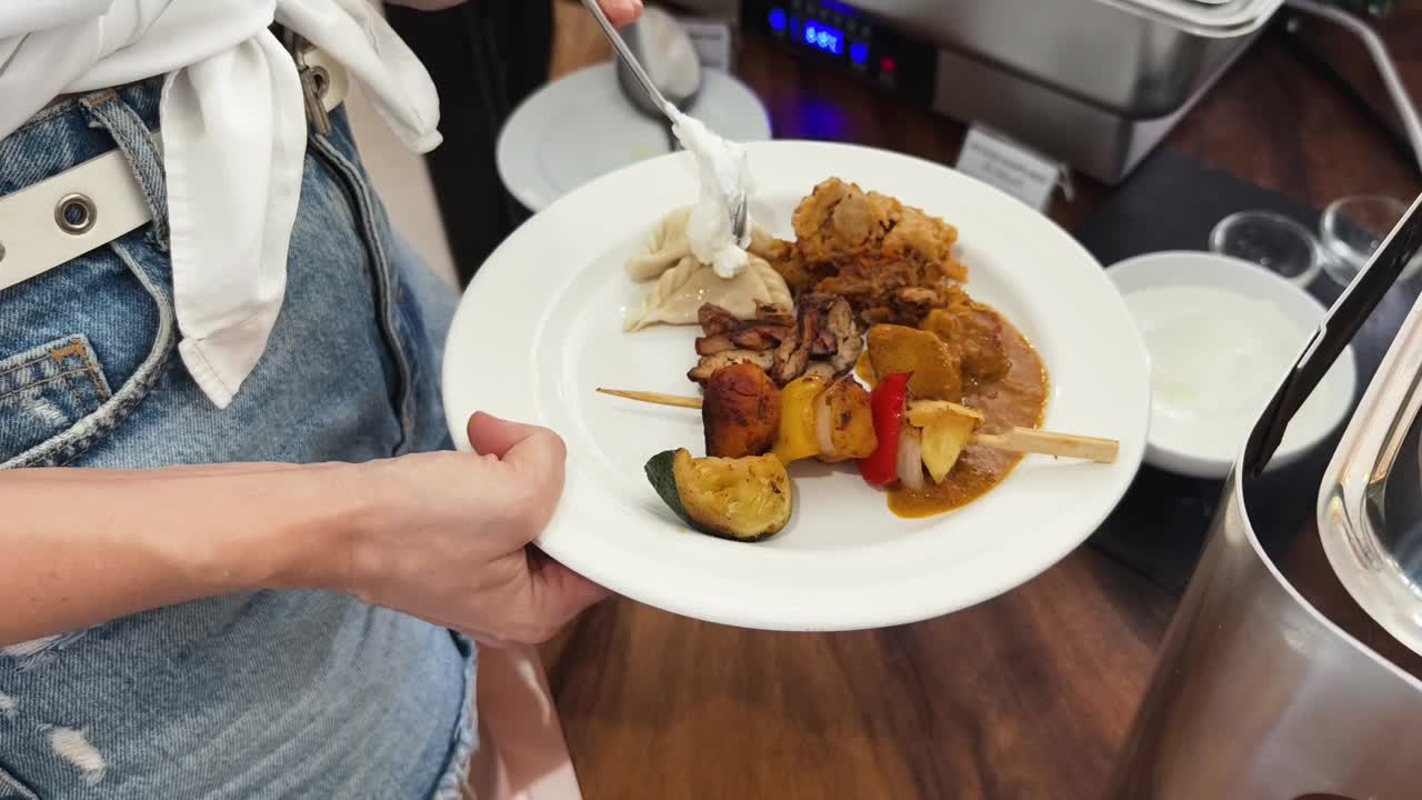 mujer sosteniendo un plato de comida en un buffet