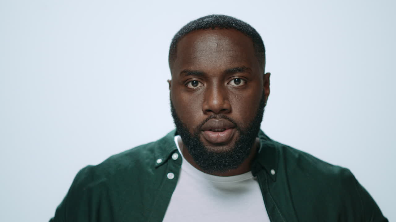 hombre africano serio preparándose para una reunión en el interior. hombre afro buscando cámara