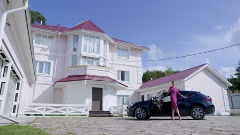 woman leaving a luxury home in a car