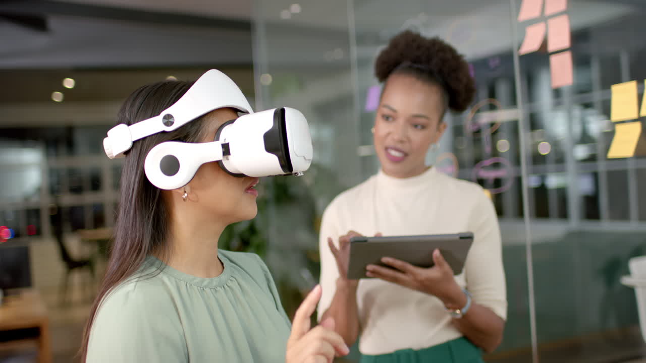 Biracial woman tries on VR headset in an office business setting, with copy space