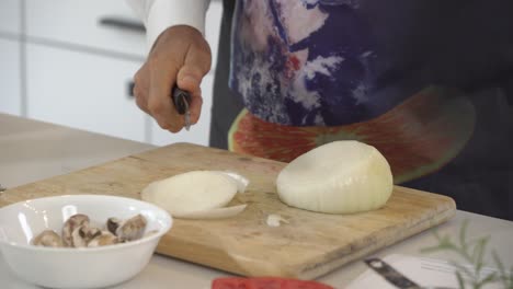 slicing a big white onion and adding pieces to food processor to make a raw vegan burger recipe