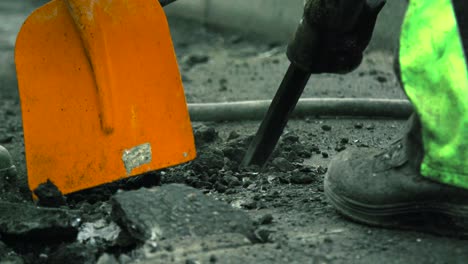 Slow-motion-of-construction-worker-using-a-jackhammer-destroying-the-asphalt-of-a-street