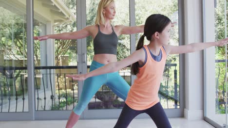 madre e hija practicando yoga en casa