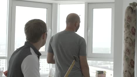 men working on a window repair in a modern apartment