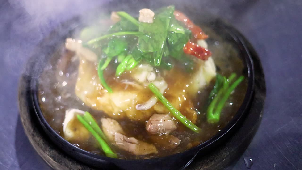 Sizzling fried noodles with vegetables and meat on hot plate, vibrant street food, steamy atmosphere