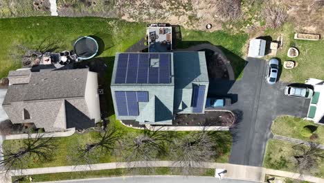 Aerial-descending-shot-of-solar-panels-on-top-of-residential-home-in-neighborhood-on-bright-sunny-day