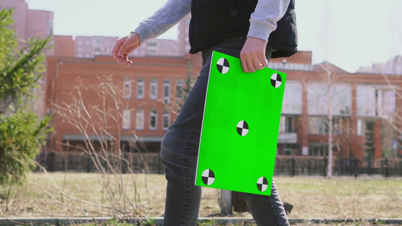 el estudiante va a la universidad después de las compras, con el paquete de pantalla verde de la tienda.