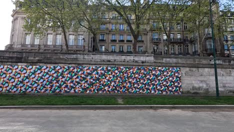 pedestrians pass a vibrant mural in paris