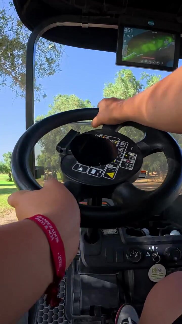 Persona che guida una golf cart in una giornata di sole