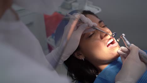 crop dentist curing tooth of female patient
