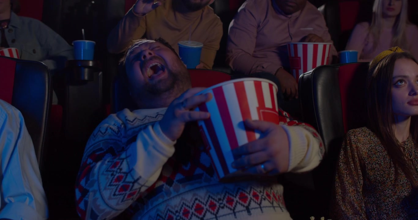 Man Laughing While Watching a Movie in a Cinema