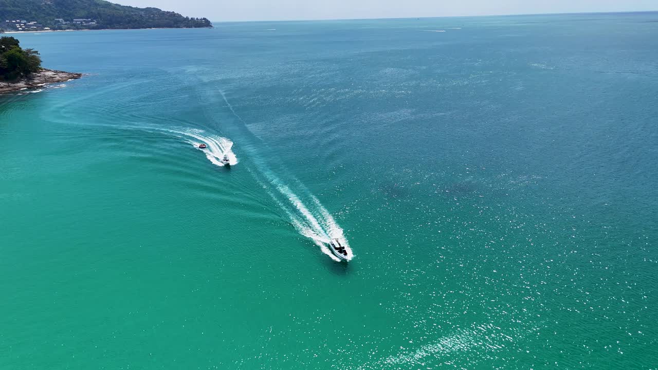 Aerial footage of a speedboat towing a banana boat in Phuket's turquoise waters, showcasing dynamic movement and vibrant scenery