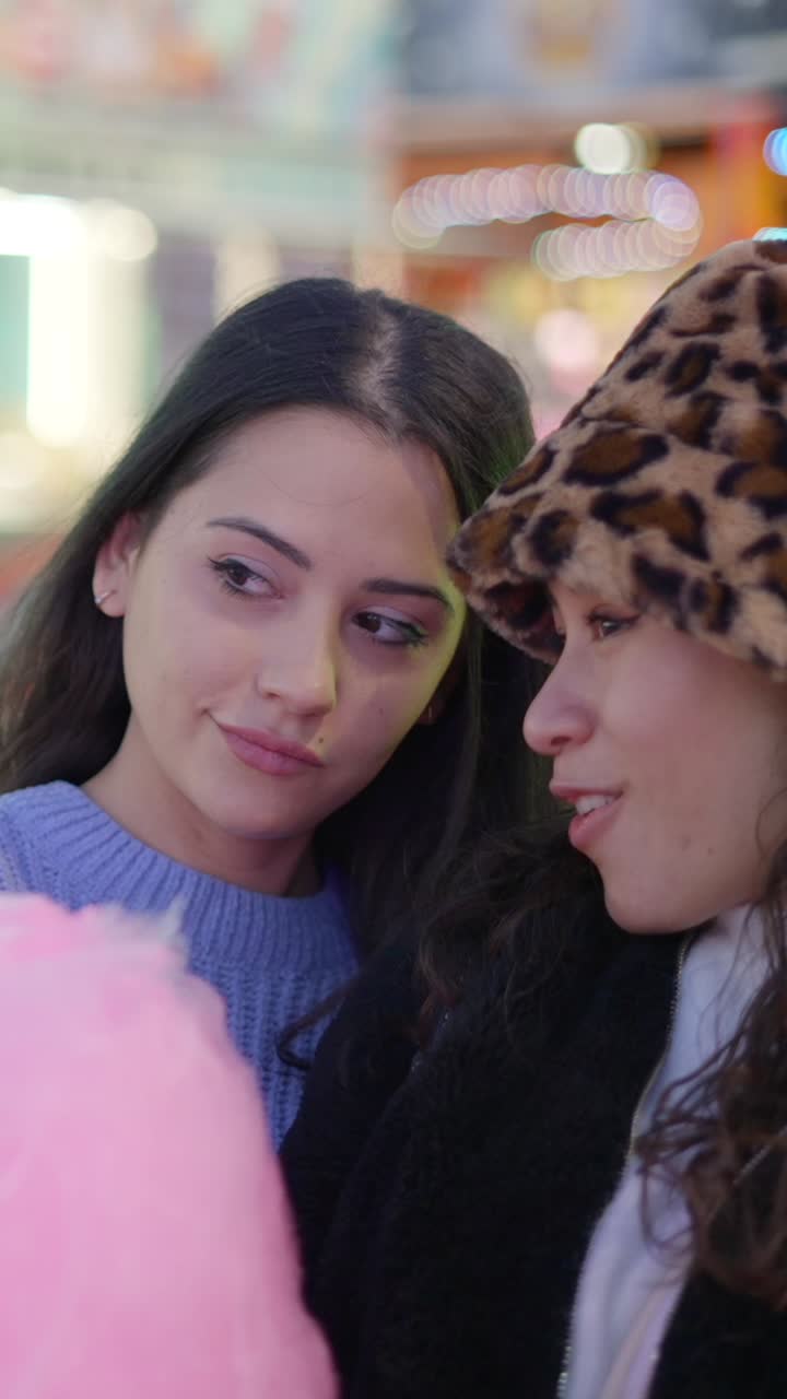 Friends enjoying cotton candy and fun moments at a fair