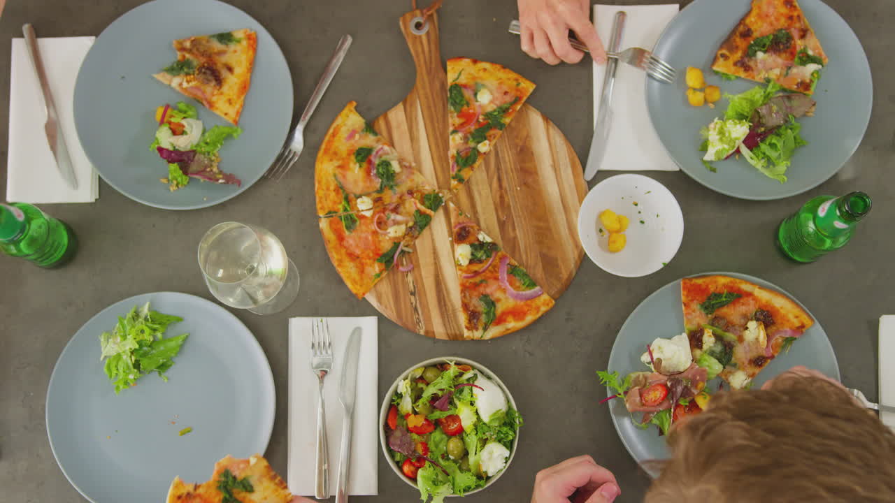 vista aérea de amigos comiendo pizza en un restaurante juntos