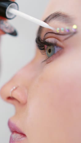 applying decorative rhinestones to eye makeup