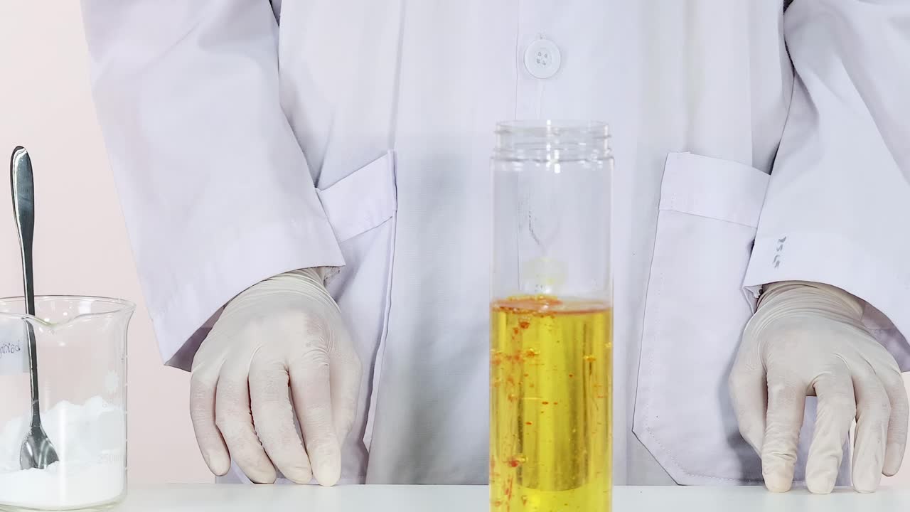 Observe a fascinating reaction as substances mix in a clear container, demonstrating basic fluid dynamics.