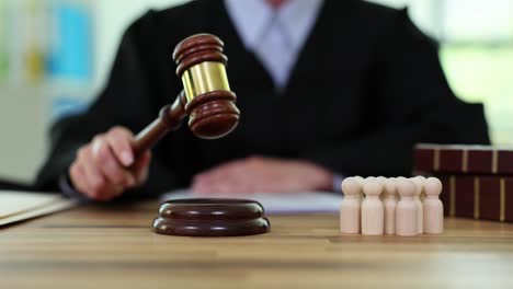 judge with gavel and wooden figures in a courtroom