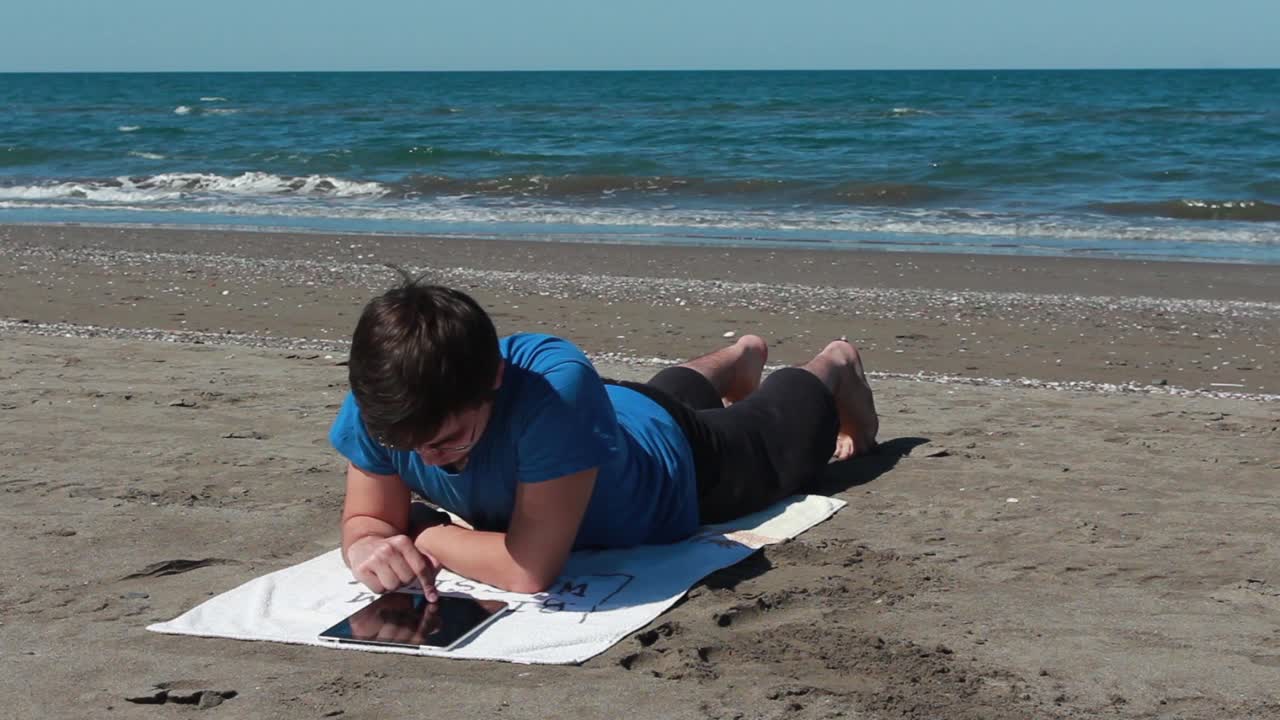 해변에서 태블릿을 사용하는 것