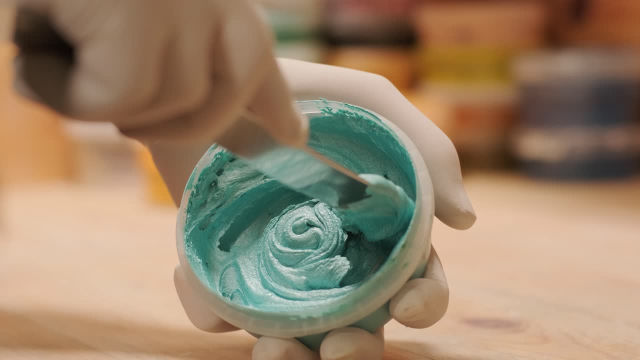 un trabajador mezcla el material para enmascarar las paredes