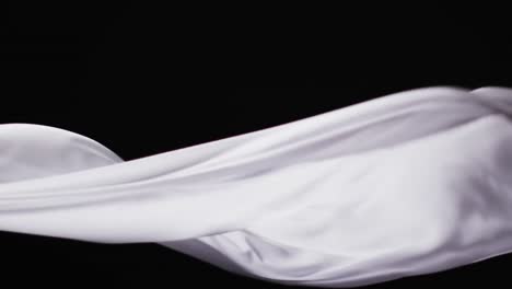 animation of white fabric blowing with copy space over black background