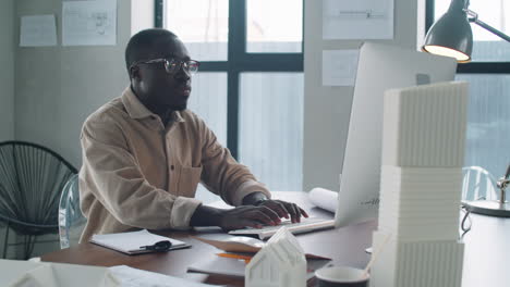 Young-African-American-Architect-Working-on-Computer-and-Taking-Notes