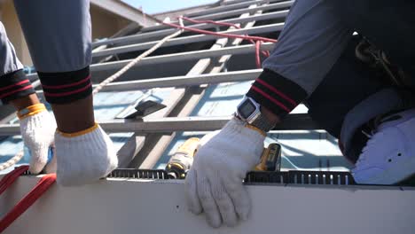 asian worker doing roof tiles installation, cutting, measuring process, close up