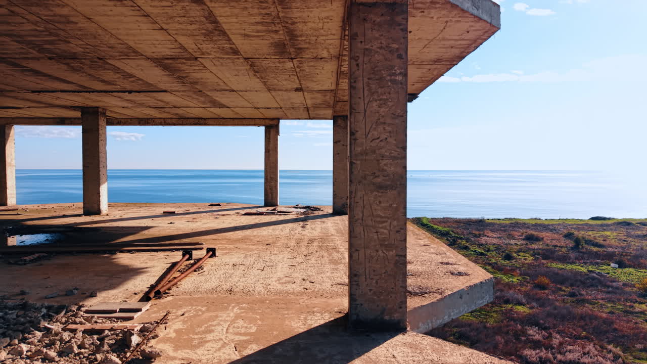 Detriti di costruzione si trovano sul pavimento dell'edificio incompiuto. Struttura abbandonata sulla riva del mare