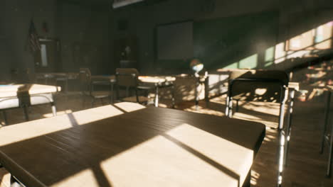 view to classroom with tables and small blackboard and grungy walls