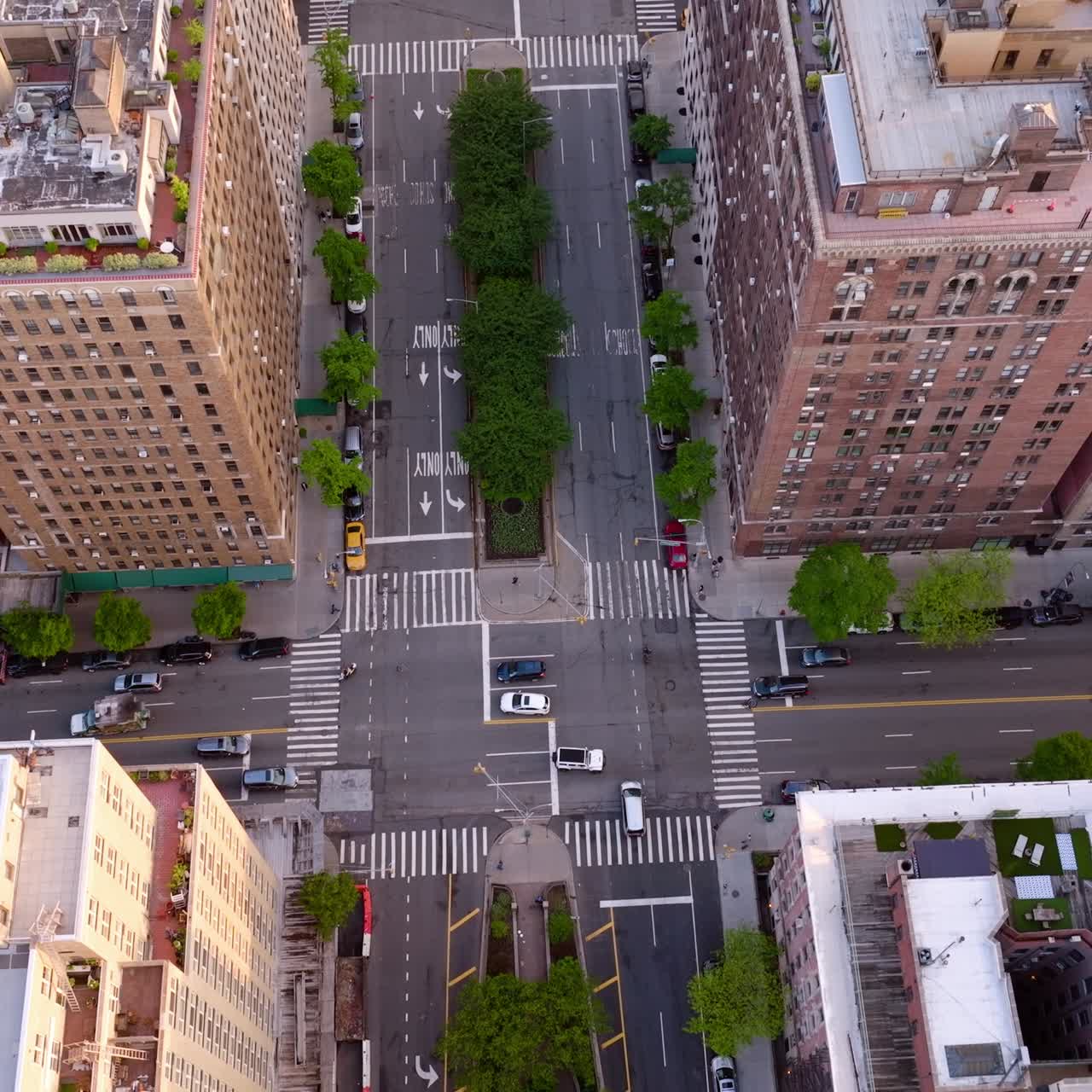 Flying over the motorways and crossroads with few cars. Multi-storied buildings towering over the streets. Top view