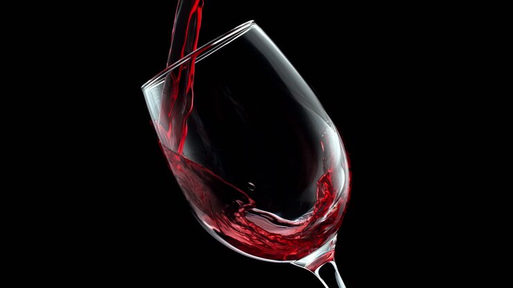 Red Wine Pouring And Swirling In Crystal Wineglass in Slow Motion On The Black Background