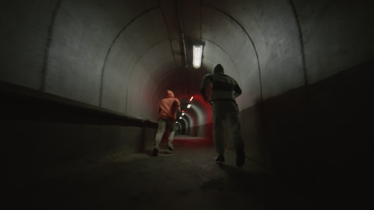 Two Boys Freerunning and Doing Parkour Flips in Tunnel