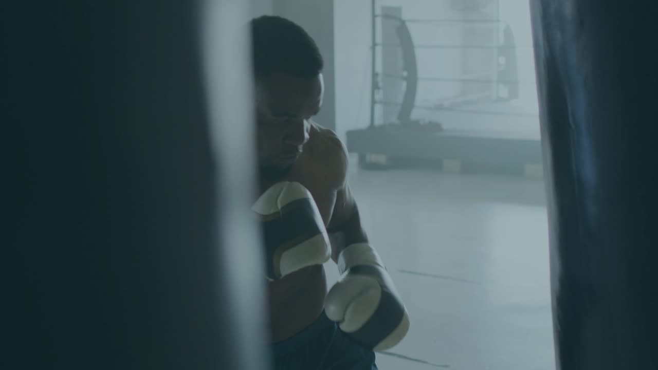 Male boxer stepping in, throwing jabs on heavy bag, training for fight, METAVERSE overlay appearing