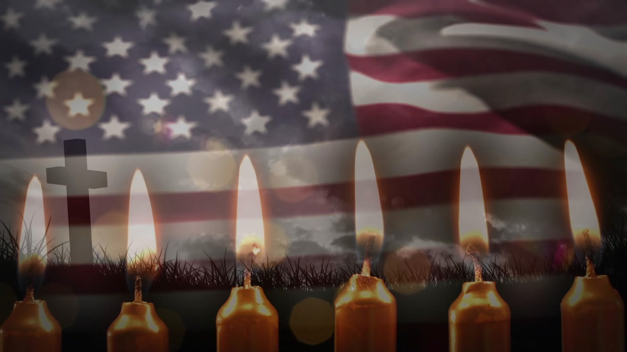 On opening seven candles flickering US flag stripes rippling over cross drifting bokeh in tribute
