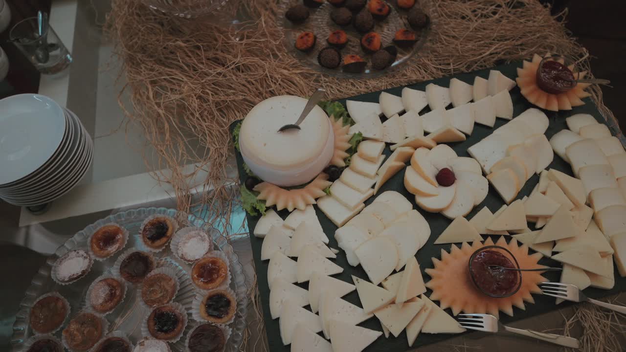 Assorted Portuguese cheeses and pastries on a rustic buffet table