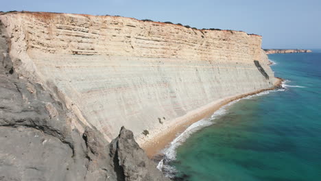 drone shot flying away from white cliffs in luz portugal