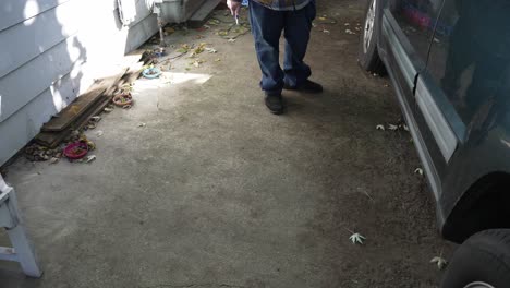 A-man-blows-leaves-out-of-their-garage-with-an-air-pressure-blower