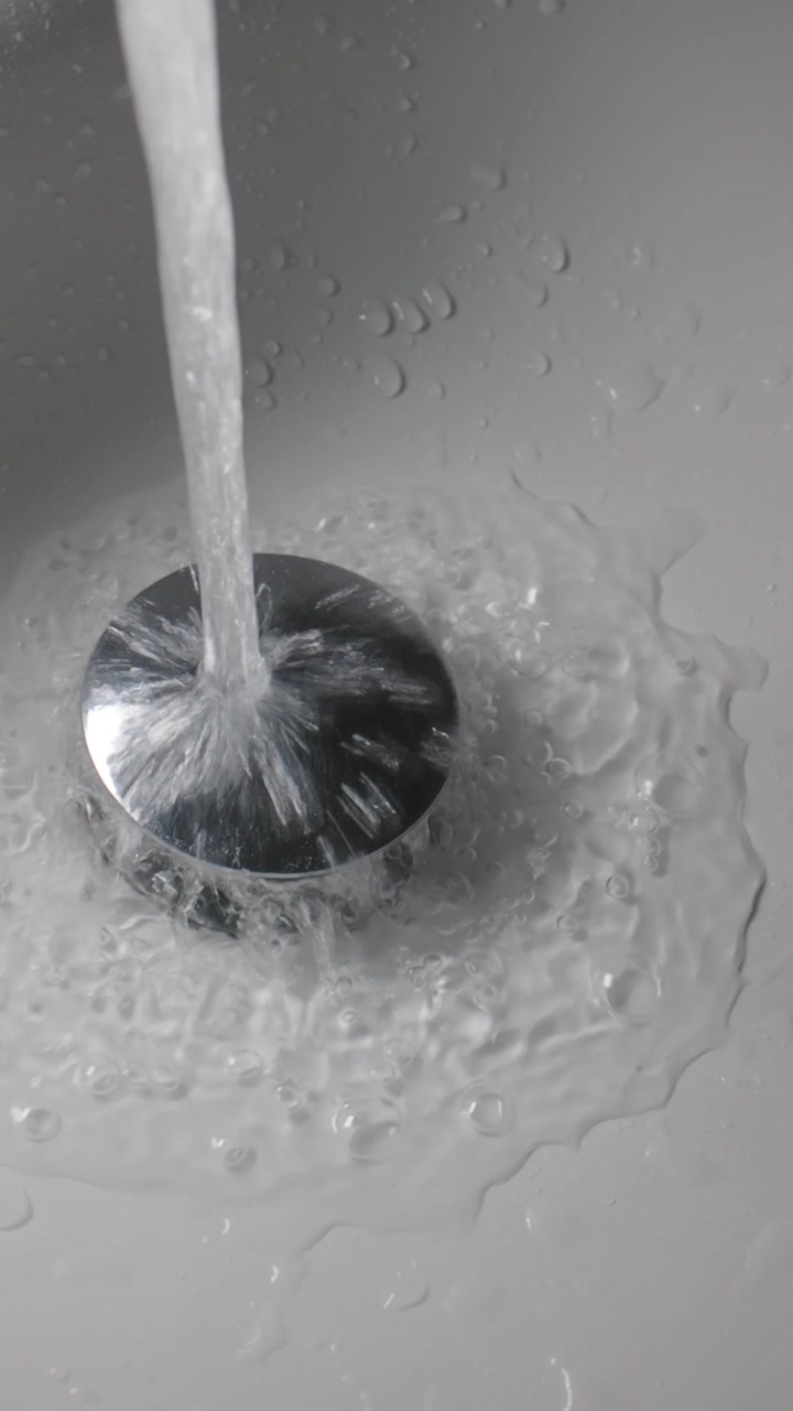 Clear Water Running into a Chrome Sink Drain