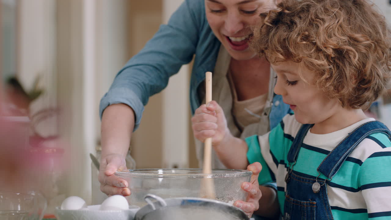 little boy helping mother bake in kitchen mixing ingredients baking choclate cupcakes preparing recipe at home