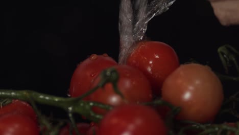 Washing-ripe-fresh-red-tomatoes-in-isolated-action-on-black-background