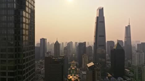 aerial view of a city skyline at dawn with modern skyscrapers emerging from a soft golden hue, creating a serene urban landscape under the morning sun