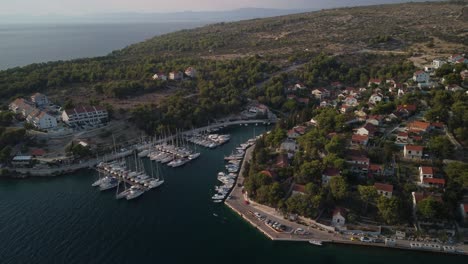 Toma-De-órbita-Aérea-De-Un-Puerto-Secundario-En-Milna,-Isla-De-Brac,-Croacia-Al-Atardecer-Con-Vistas-Panorámicas-Sobre-El-Agua-Turquesa-Del-Mar-Adriático