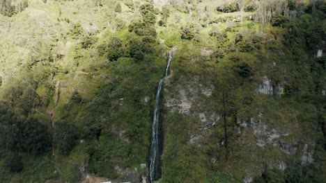 Aerial-View-Of-Cascada-de-la-Virgen-Flowing-Down-On-Green-Cliff-In-Baños-de-Agua-Santa,-Ecuador---drone-shot