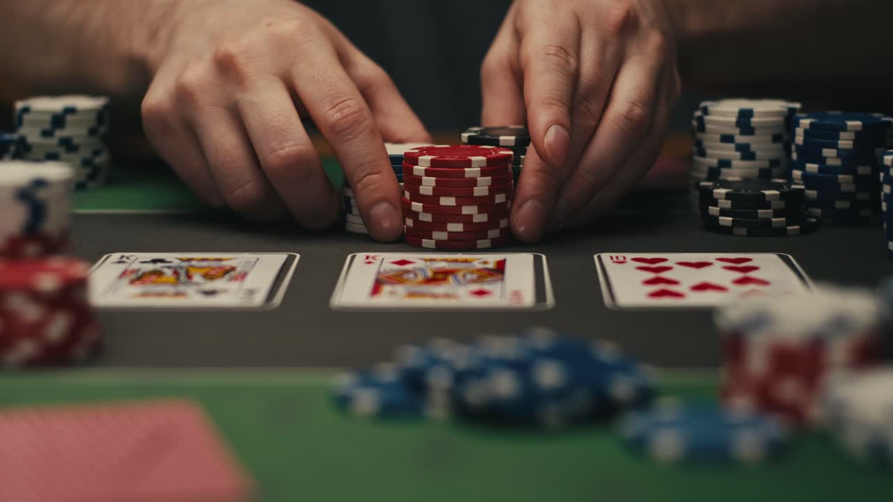 Hands managing poker chips on green table, reflecting intense poker gameplay with the element of chance and skill